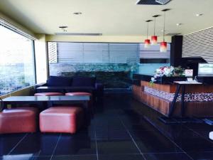 a restaurant with couches and a table and chairs at Prachuap Beach Hotel in Prachuap Khiri Khan