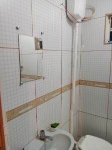 a bathroom with a sink and a toilet at Hostel pousada jardim glória in Limeira
