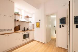a kitchen with white cabinets and a wooden floor at 1BR Stylish Apt 20 Minutes from Acropolis in Athens