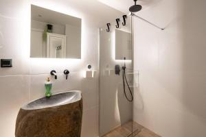 a bathroom with a sink and a shower at 1BR Stylish Apt 20 Minutes from Acropolis in Athens +26 photos