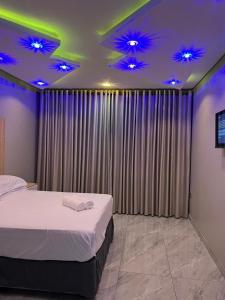 a bedroom with a bed and purple lights on the ceilings at Annie's Guest Lodge in Volksrust