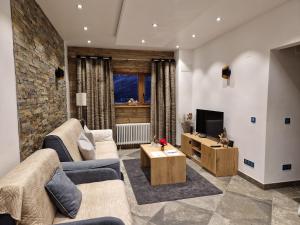 Una sala de estar con dos sofás y un televisor. en Le Slalom, en Tignes