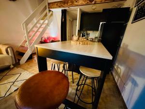 a kitchen with a bar with stools and a counter top at Résidence Le SUNSET Marseillan-plage, entre mer, canal du midi et lagune de Thau, étape vélo, famille, couple, VRP, toutou admis, jardin, parking privé gratuit, vélos, Clim, WIFI fibre gratuite, commodités, plage et piste cyclable à proximité in Marseillan