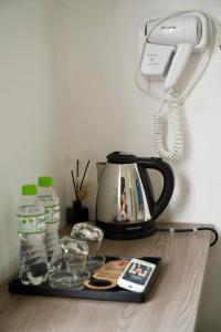 a tea kettle and a phone on a table at Gia Hung Motorbike & Home Stay in Hanoi +21 photos