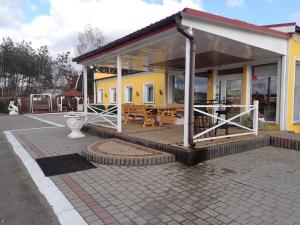 a yellow building with a patio with a table at Noclegi Kochlice in Kochlice