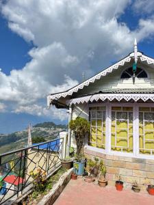 un edificio con un balcón con plantas. en Eagle's Nest Homestay, en Darjeeling 35 fotos más