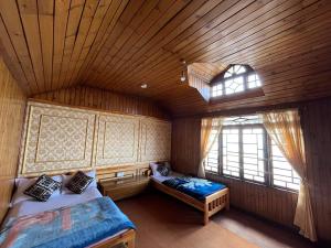 Habitación en el ático con 2 camas y ventana en Eagle's Nest Homestay, en Darjeeling