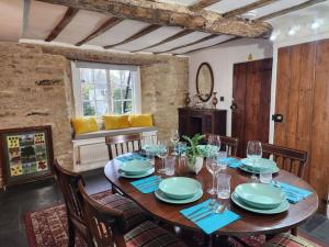 a dining room with a wooden table and chairs at Swan Cottage, 5-Bedroom, Canal View, River, Private gardens, Free Parking's, WiFi, Oxford in Kidlington