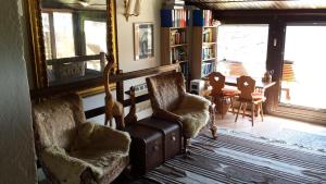 ein Wohnzimmer mit 2 Stühlen und einem Tisch in der Unterkunft Seehaus Weiss in Rothenthurn