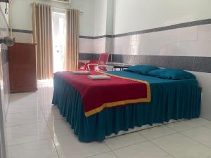 Khách Sạn Kim Thanh في مدينة هوشي منه: غرفة نوم بسرير وبطانية زرقاء وحمراء