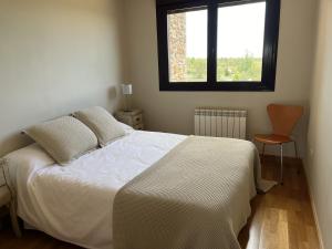a bedroom with a bed and a window and a chair at Casa con vistas al lago golf leon in León