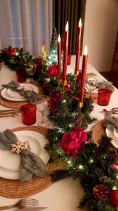 a table with a christmas centerpiece with candles on it at L'Orée des Champs in Magny-Fouchard