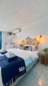 a bedroom with a large bed with blue blankets on it at Suite Caraïbes 2 - Superbe Studio Cosy Vue Mer in Les Trois-Îlets