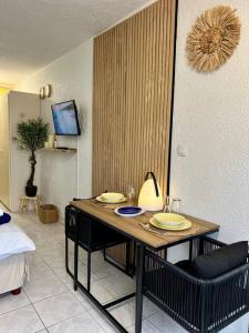 a room with a table with plates on it at Suite Caraïbes 2 - Superbe Studio Cosy Vue Mer in Les Trois-Îlets +44 photos