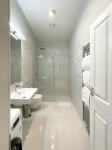 a white bathroom with a sink and a toilet at Powder Tower Residence in Prague