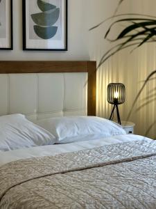 a bedroom with a white bed with a headboard and a lamp at Powder Tower Residence in Prague