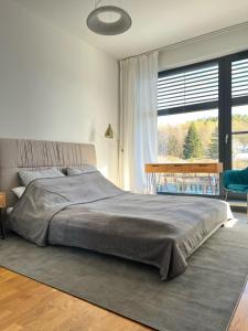 a bedroom with a large bed and a large window at Happy Moments - widokowy apartament in Jelenia Góra