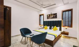 ein Schlafzimmer mit einem Bett, einem Tisch und Stühlen in der Unterkunft Itsy Hotels Vedansh in Ludhiana + 30 Fotos