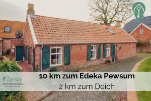 an image of a brick house with the words km zkm edgewza at Huuske bi de kark in Krummhörn