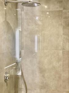 a shower with a glass door in a bathroom at ApartmentInCopenhagen Apartment 1501 in Copenhagen