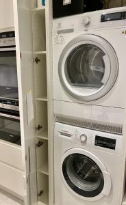 a washer and dryer in a white closet at ApartmentInCopenhagen Apartment 1501 in Copenhagen