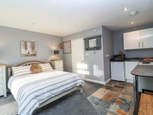 a small bedroom with a bed and a kitchen at Studio Apartment in Minehead