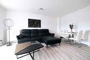a living room with a black couch and a table at Schiffbrücke in Flensburg
