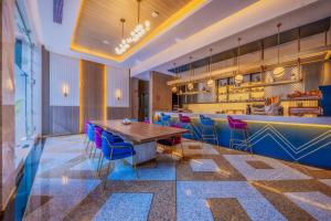 a restaurant with a wooden table and blue chairs at Glee Nairobi, a Preferred LVX Hotel in Nairobi