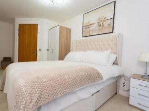 1 dormitorio blanco con 1 cama grande y puerta de madera en Valdeni Apartments, en Leeds
