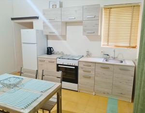 een keuken met een fornuis, een wastafel en een tafel bij St Michael's House in Birgu +3 foto's