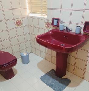 een badkamer met een rode wastafel en een toilet bij St Michael's House in Birgu