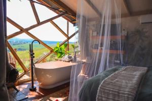 y baño con ventana grande y bañera. en Quaint Luxury Villas, en Graskop