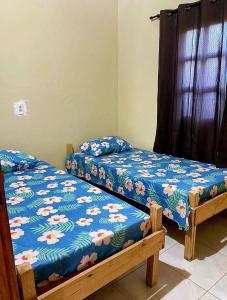 two beds sitting next to each other in a room at Casadijaina in Amontada