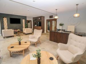 a living room with chairs and a table at 2 Rock Mill Holiday Apartments in Eyam