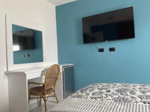 a bedroom with a bed and a tv on a wall at All Seasons Hotel in Bayahibe