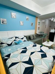 a bedroom with a large bed with a blue wall at Beach Vibe Condo with PS4, Mini Karaoke, Board Games in Azure North San Fernando Pampanga in San Fernando +22 photos
