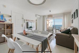 una sala de estar con una mesa y un sofá en Bonito Apartamento en Frente del Mar, en Jávea