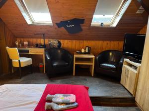 a room with two chairs and a bed and a desk at Henblas Hotel in Altenaffeln