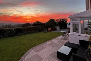 a view of a sunset from the backyard of a house at The Hidden Valley - a stylish rural retreat, perfect for families in St Clears +19 photos