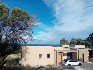 une maison avec une voiture garée devant dans l'établissement Un air de paradis à Corbara, à Corbara