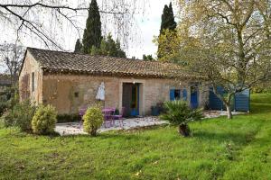 a small stone house in a yard at La Maison D'amis Du Chateau in Pech-Luna