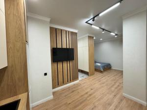 a room with a television and a bed in a room at Уютная квартира в Бухар Жырау in Astana +1 photo