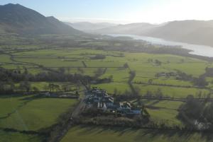 an aerial view of a house in a field next to a lake at The Castle Inn Hotel by BW Signature Collection, Keswick in Keswick