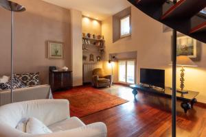 a living room with white furniture and a tv at RK Pescherie Vecchie in Bologna