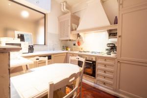 a kitchen with white cabinets and a table and chairs at RK Pescherie Vecchie in Bologna