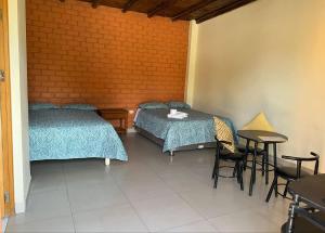 a room with two beds and a table and chairs at Hospedaje La Huega in Ica +79 photos