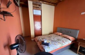 a small bedroom with a bed and a fan at Hospedaje La Huega in Ica