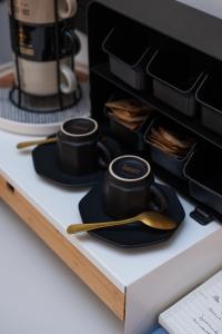 a table with two black plates and a coffee maker at "Versace" Luxury Suite in Centro Città, a 350m dal Mare, Scopri la tua offerta SPECIALE! in Pescara