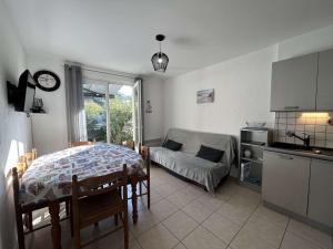 a kitchen and a living room with a table and a couch at Maison de Vacances avec Terrasse Dallée, 6 Couchages, à Deux Pas de l'Océan à St-Jean-de-Monts - FR-1-224C-94 in Saint-Jean-de-Monts +16 photos