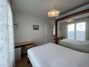 a bedroom with a white bed and a window at Maison de Vacances avec Terrasse Dallée, 6 Couchages, à Deux Pas de l'Océan à St-Jean-de-Monts - FR-1-224C-94 in Saint-Jean-de-Monts